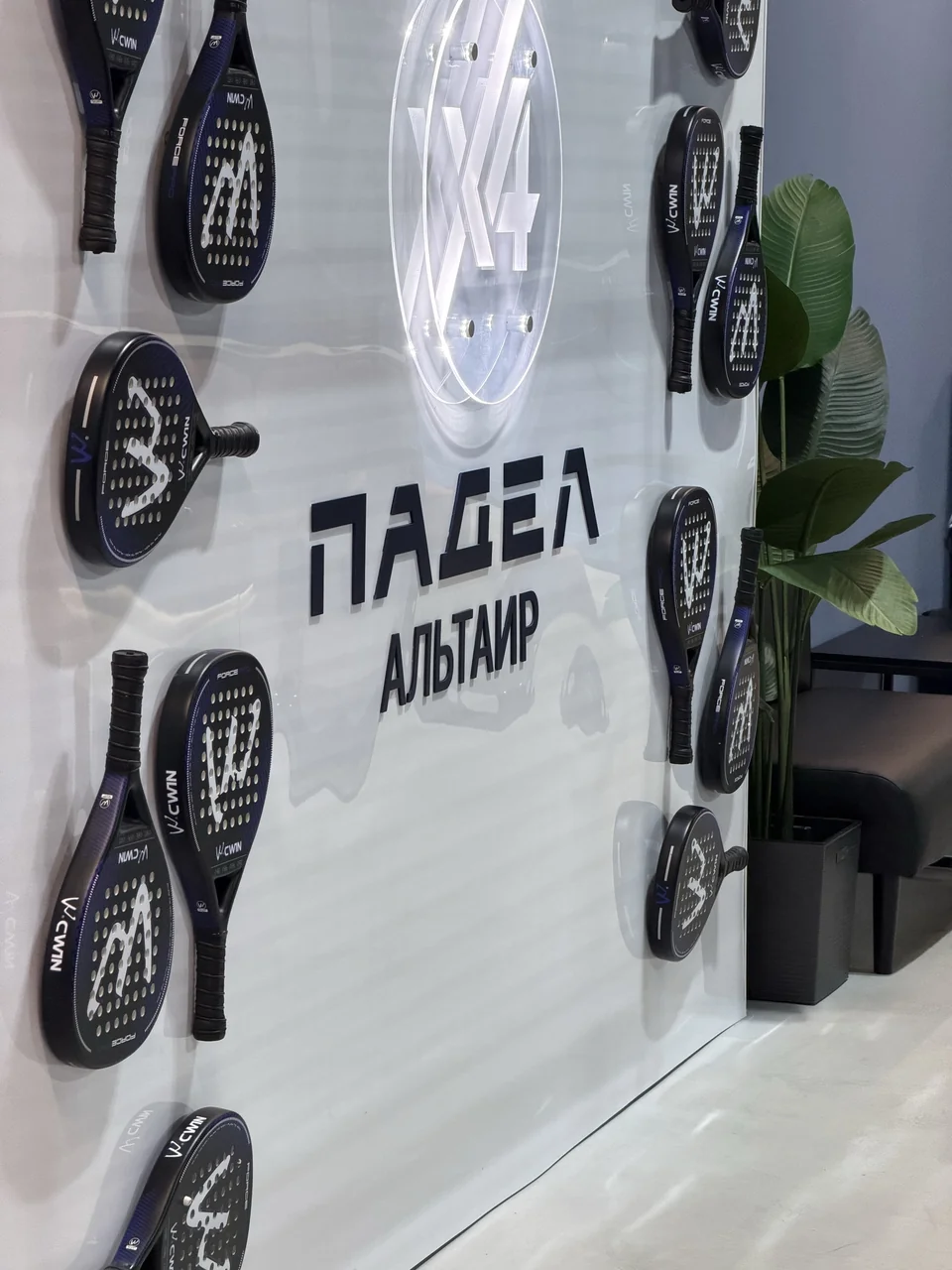 Стена с ракетками и надписью «Падел Альтаир»